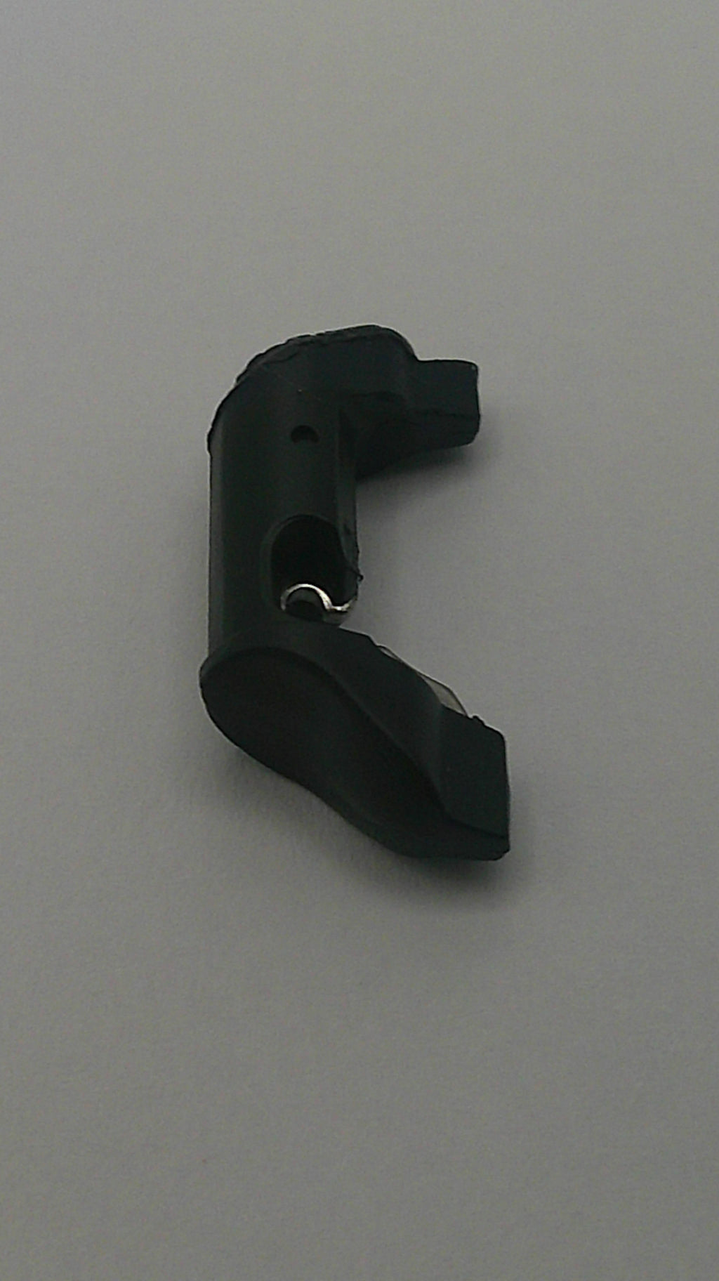 Black plastic component on a gray background