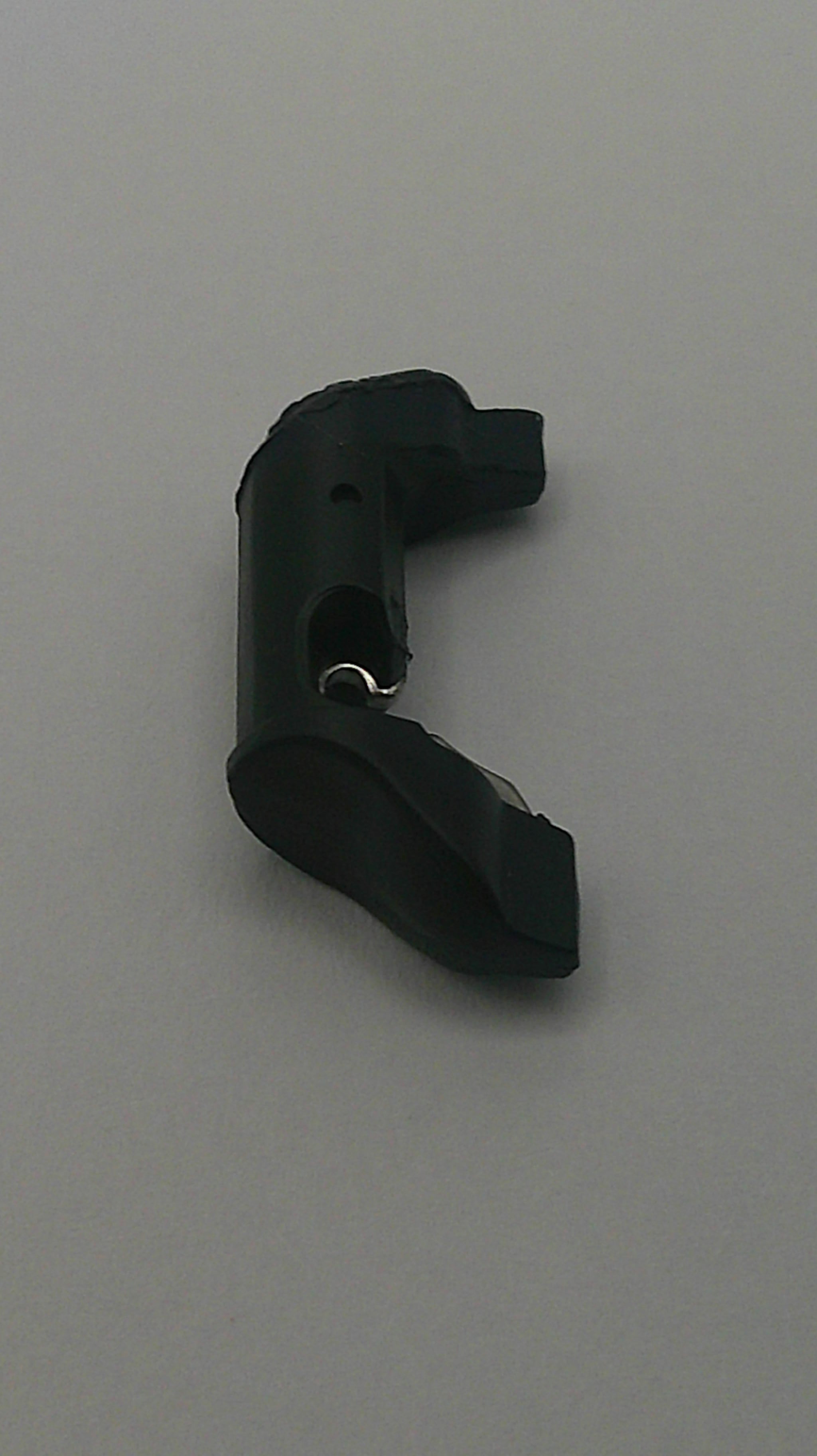 Black plastic component on a gray background