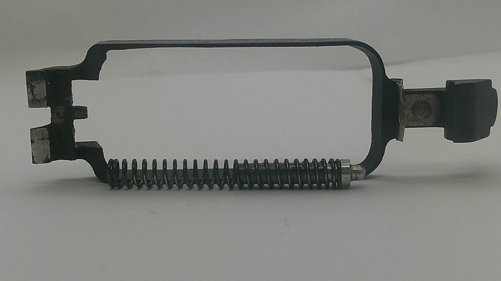 A black metal mechanical component with a coiled spring and a small black knob, photographed on a plain light background.