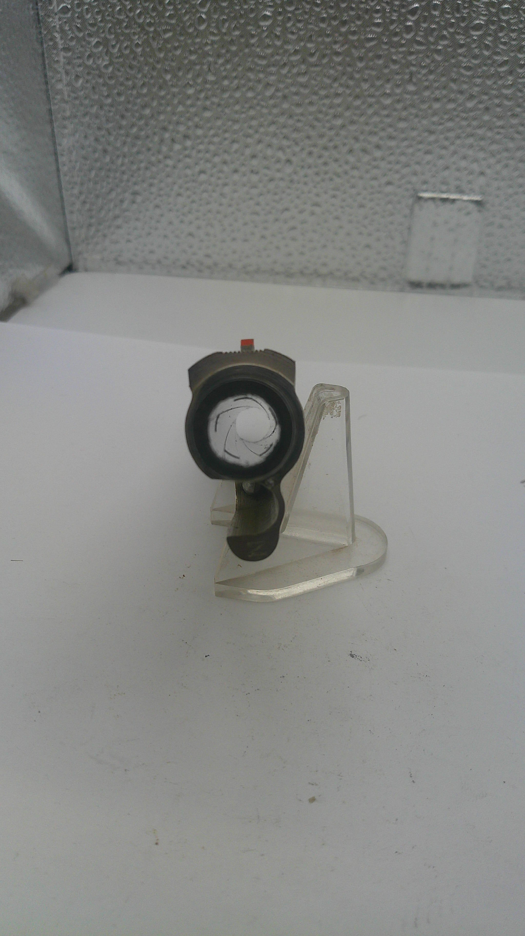Mechanical component on a white stand with a textured wall background