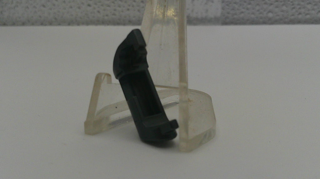 Clear plastic stand with a black object on a white surface