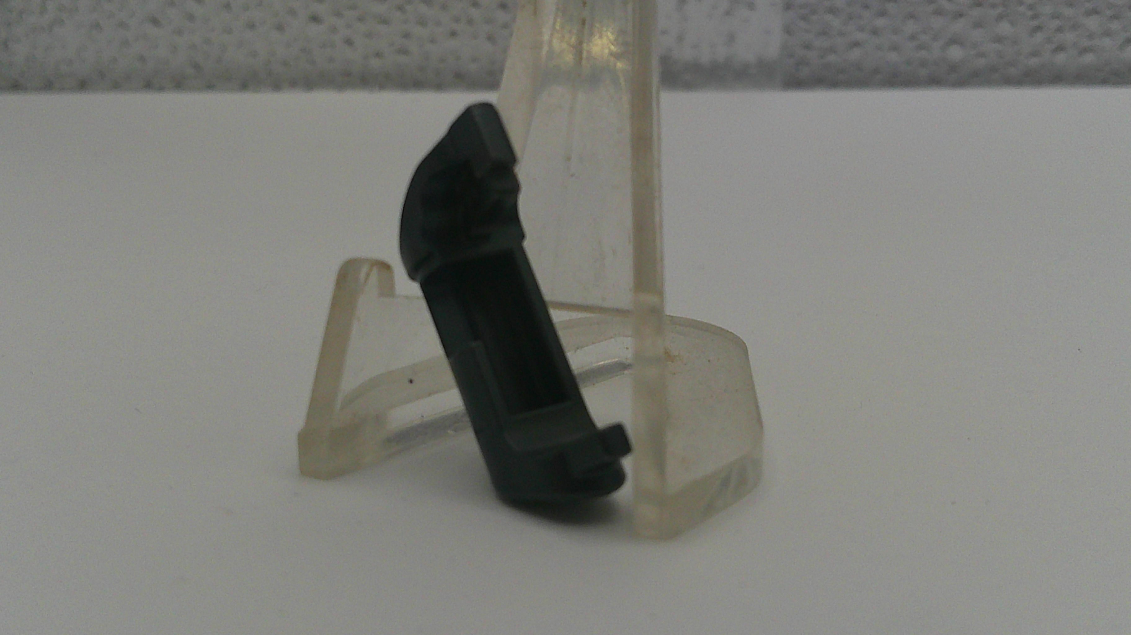 Clear plastic stand with a black object on a white surface