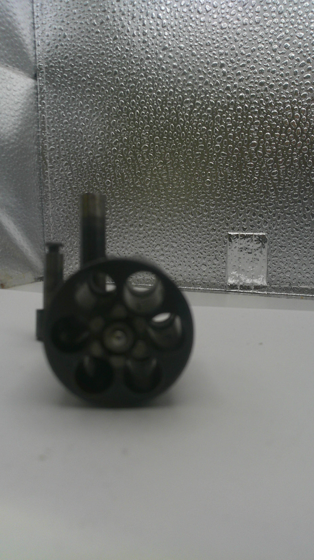 Black cylindrical object on a textured gray surface