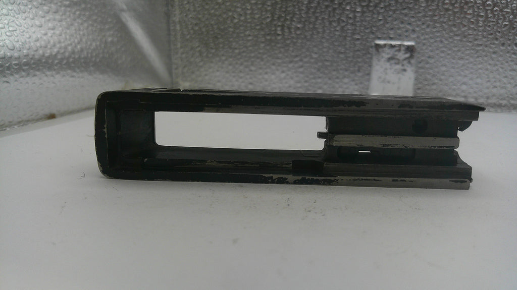 Black metal bracket on a white surface with a reflective silver background