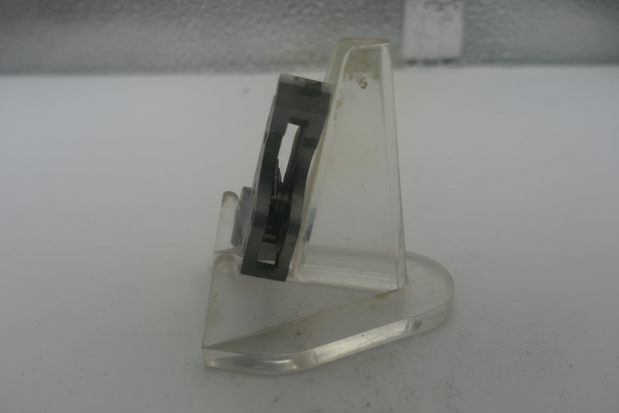Metal bracket on a textured white surface
