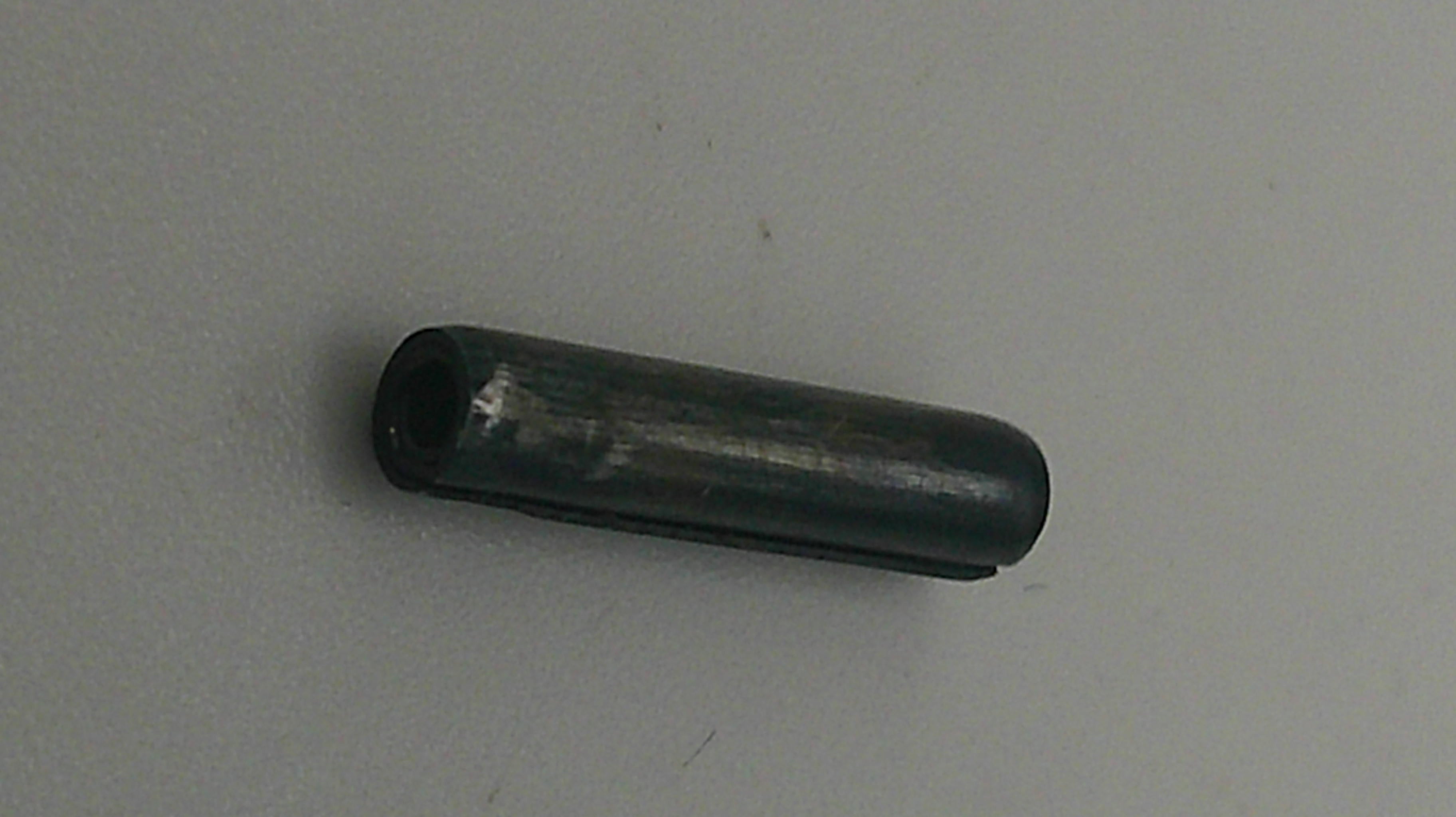 Black cylindrical object on a gray background