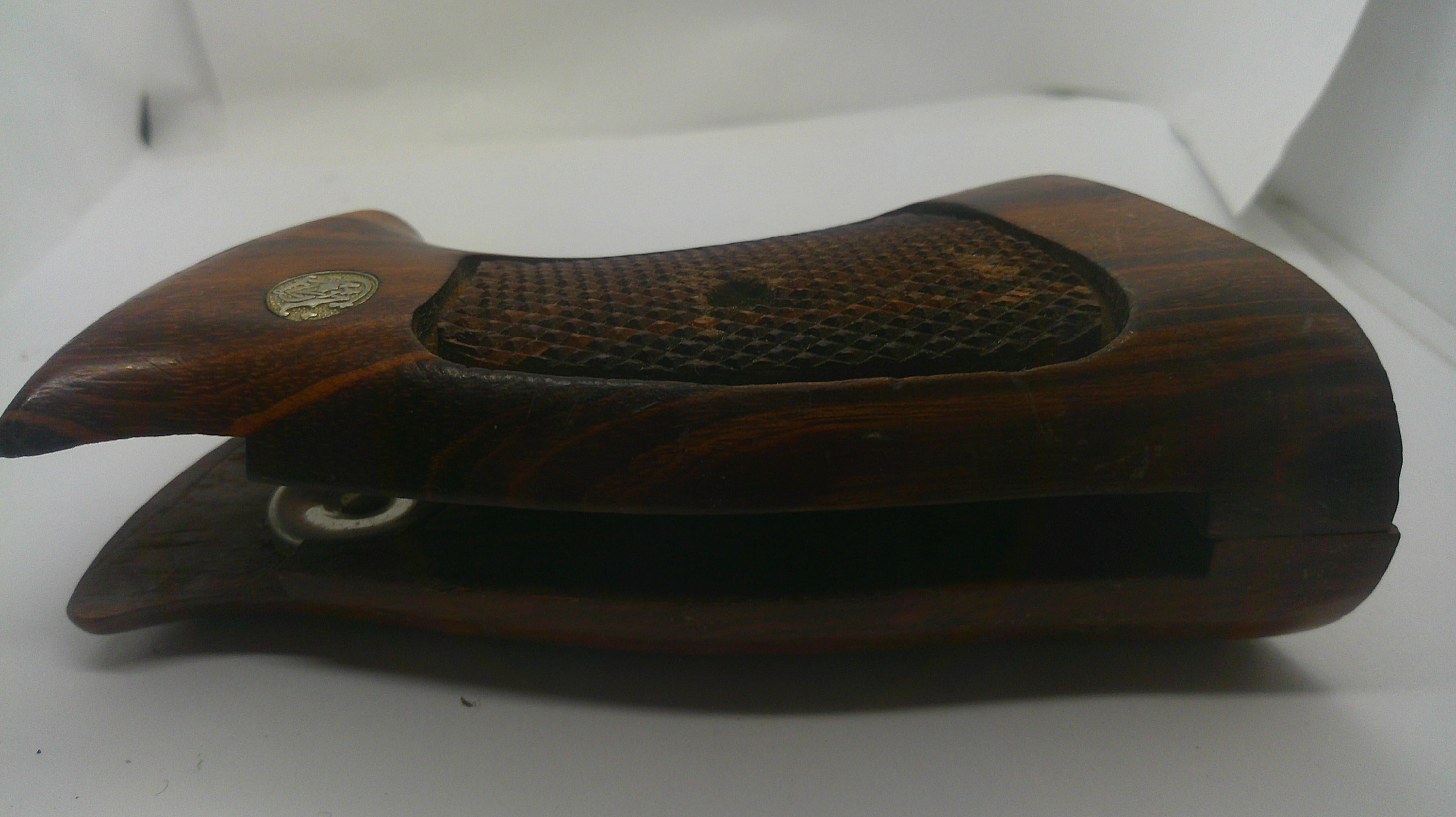 A vintage wooden object with a dark brown carved handle and a textured grip, photographed on a white background.