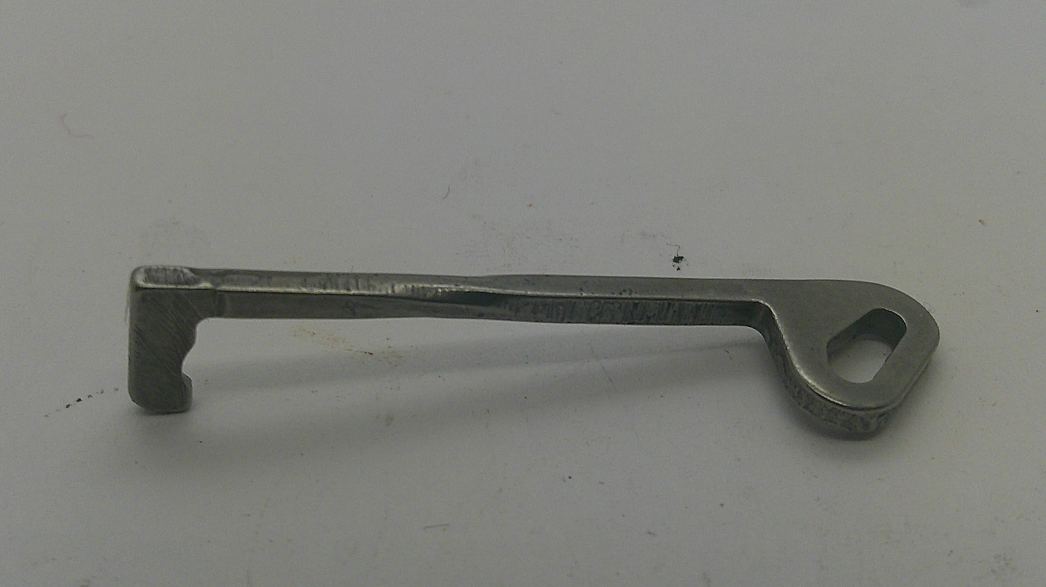 A small metal key-shaped tool with a looped end, photographed on a plain light background.
