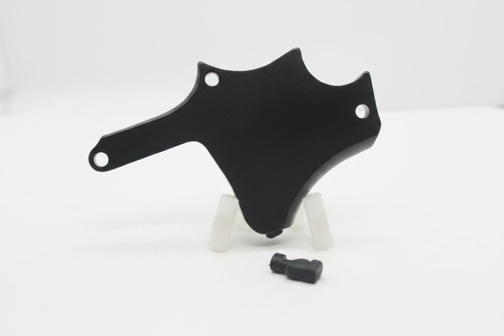 A black metal mounting bracket or cover with pre-drilled holes, displayed on a small clear stand against a plain light gray background.