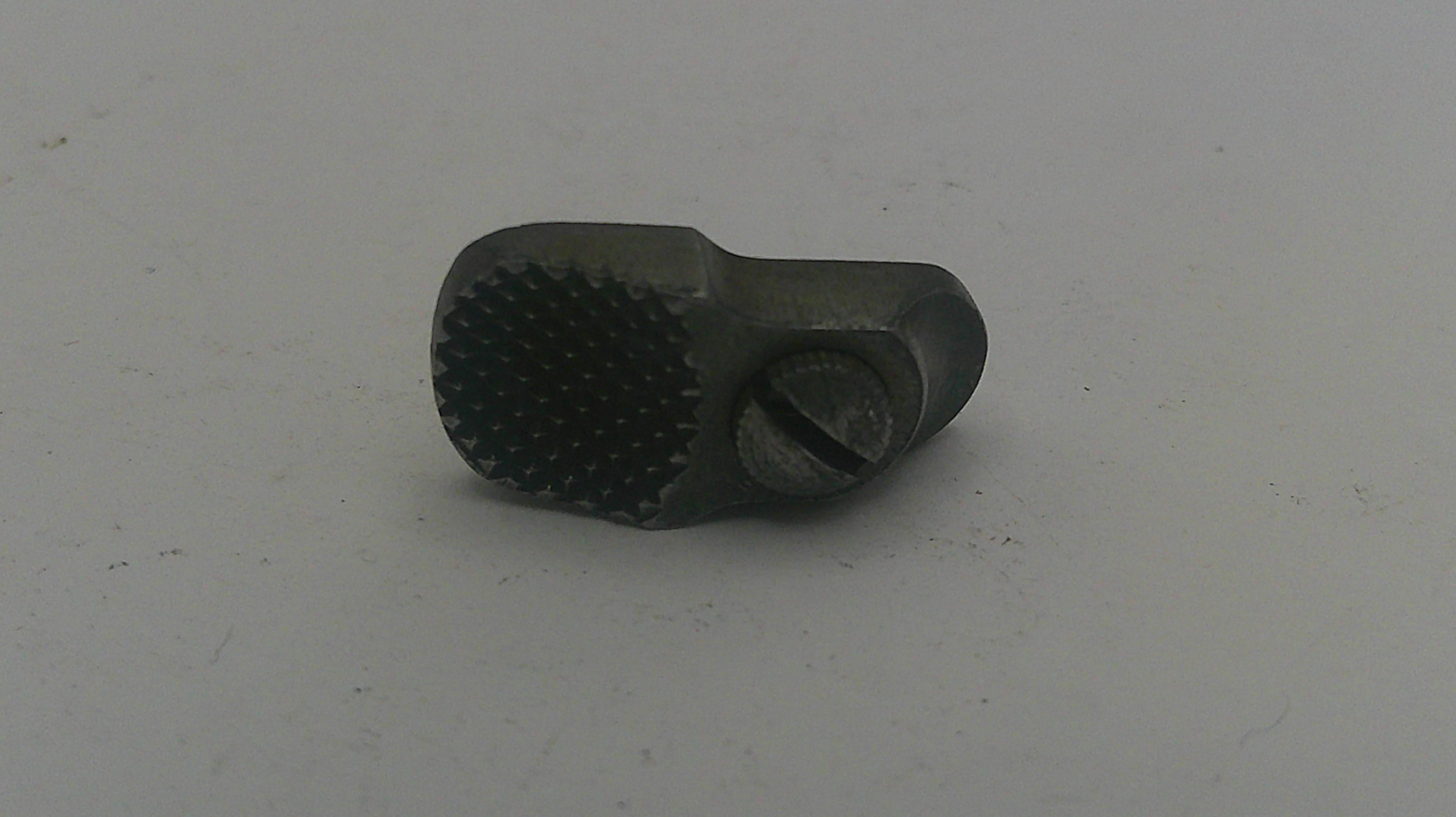 Metal tool with textured surface on a light gray background