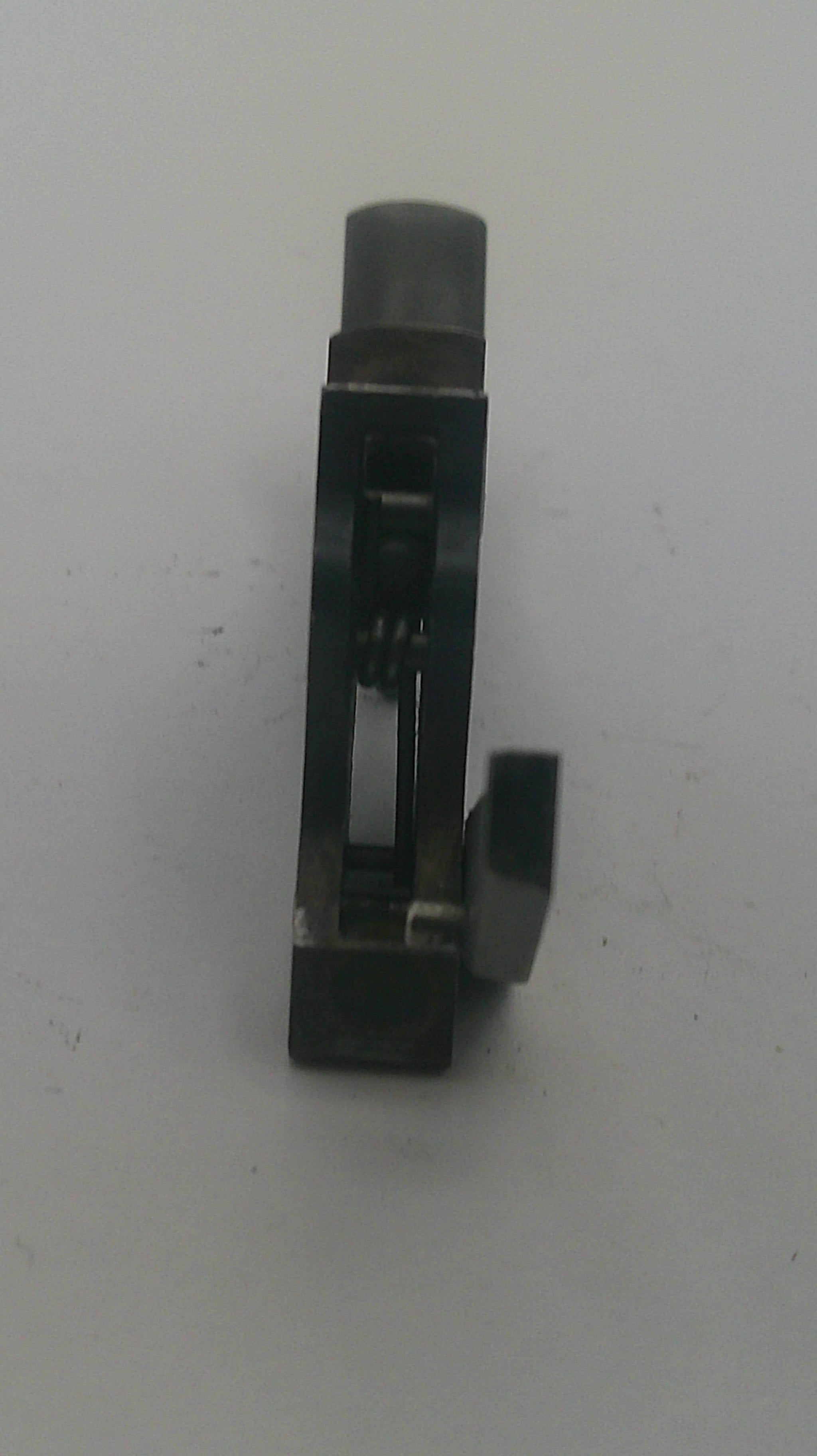 A small black metal mechanical component or tool part with a cylindrical end, photographed on a plain light background.