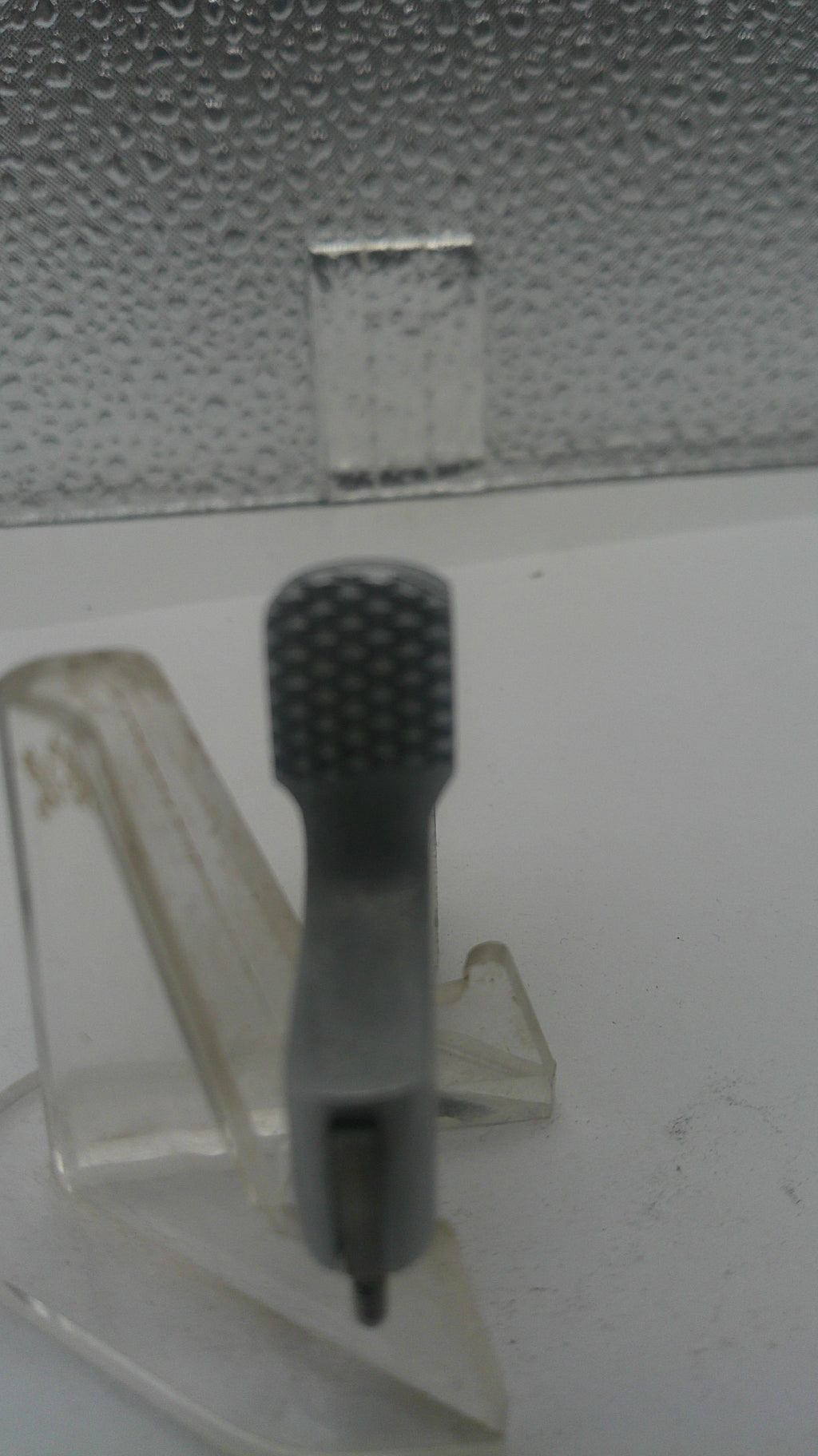 Black textured tool on a metallic surface