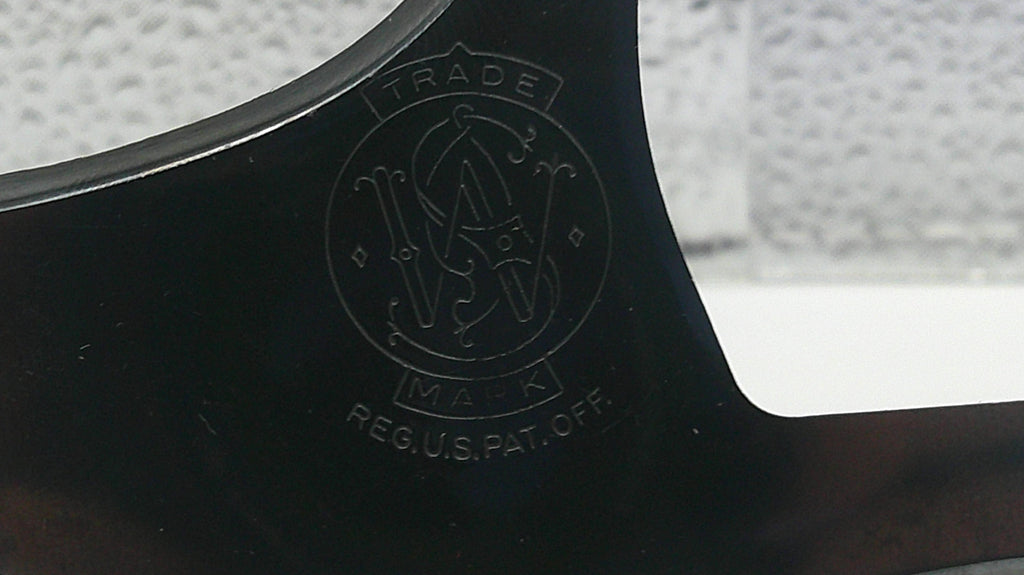 Close-up of a black object with a logo and text on a blurred background