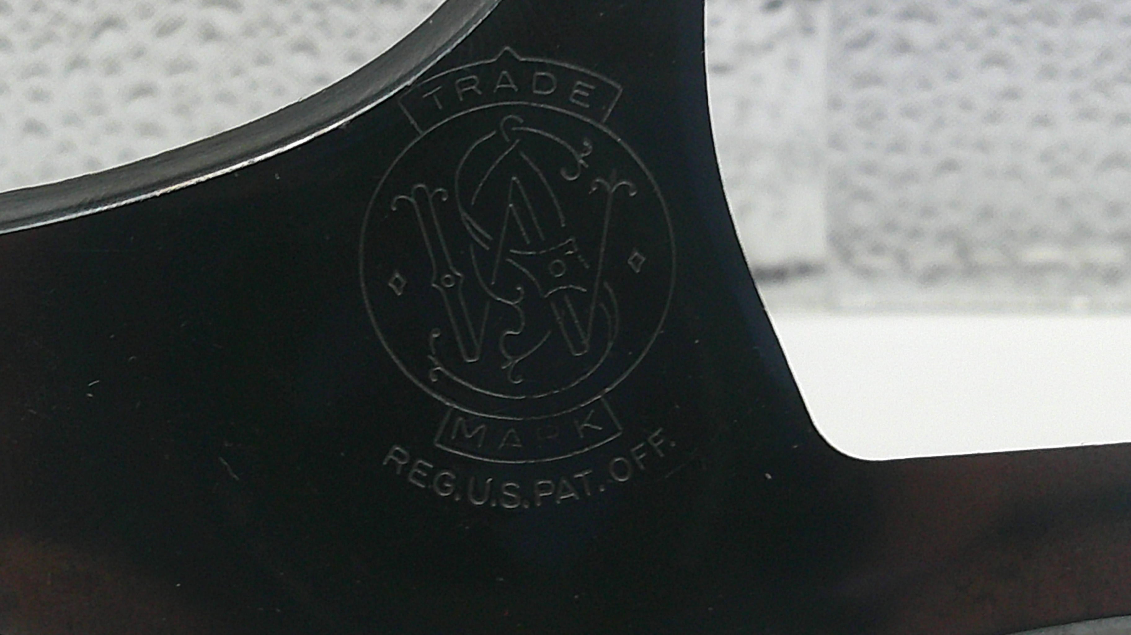Close-up of a black object with a logo and text on a blurred background