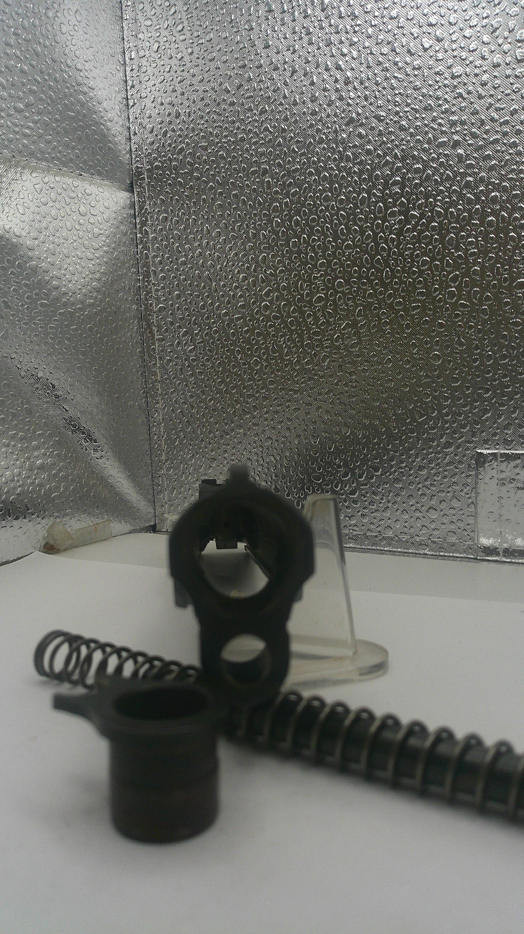 Close-up of a black metal component on a textured surface