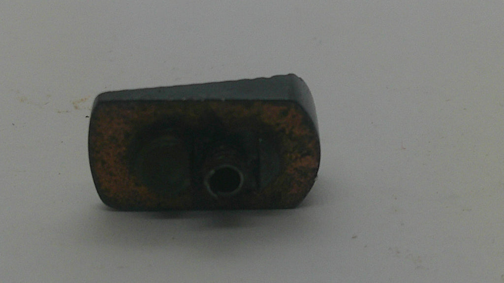 A small dark metal mechanical component with a rusted brown surface, photographed on a plain light gray background.