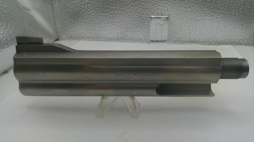 Metal cylindrical component on a white surface with a textured gray background