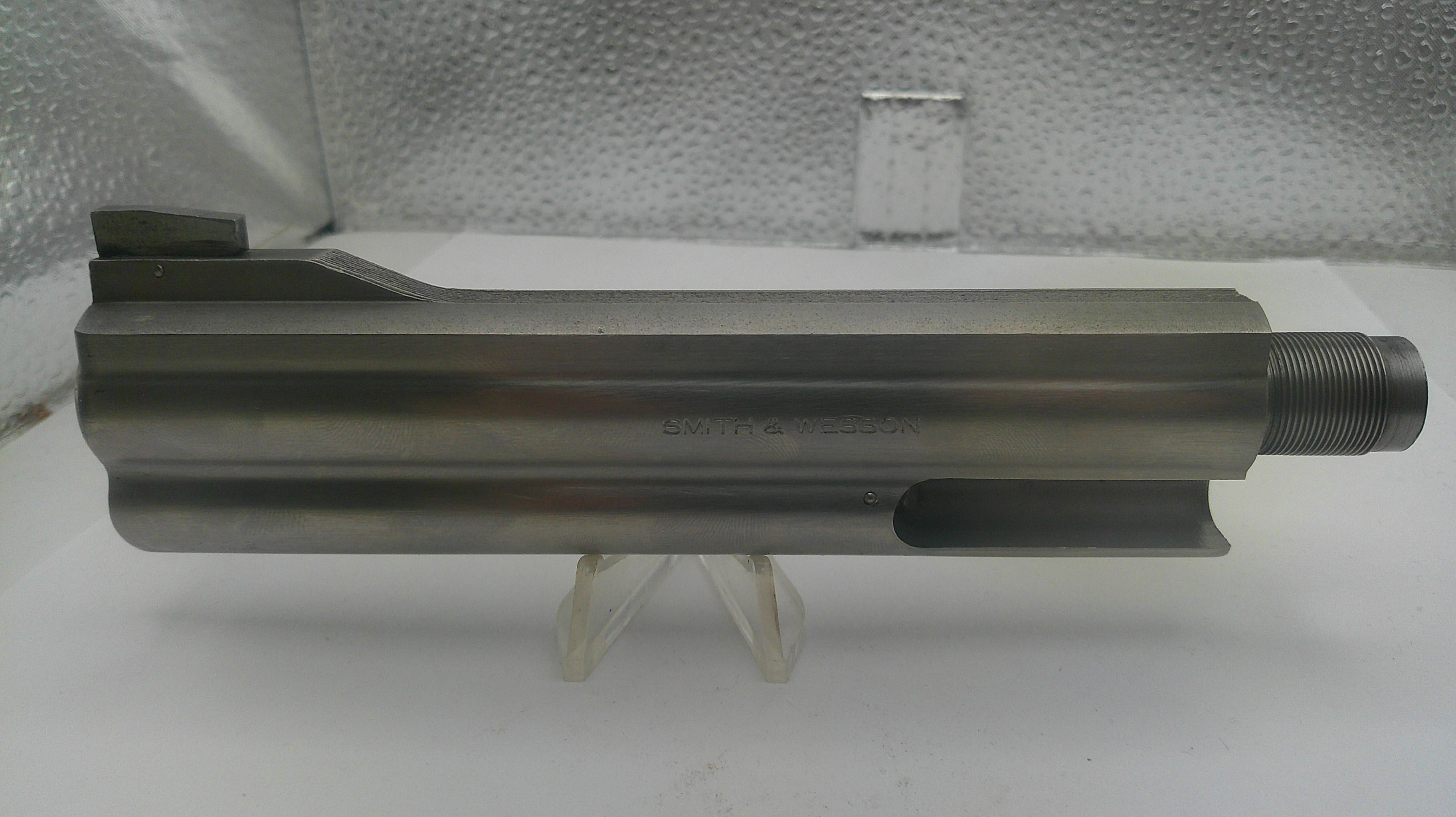 Metal cylindrical component on a white surface with a textured gray background