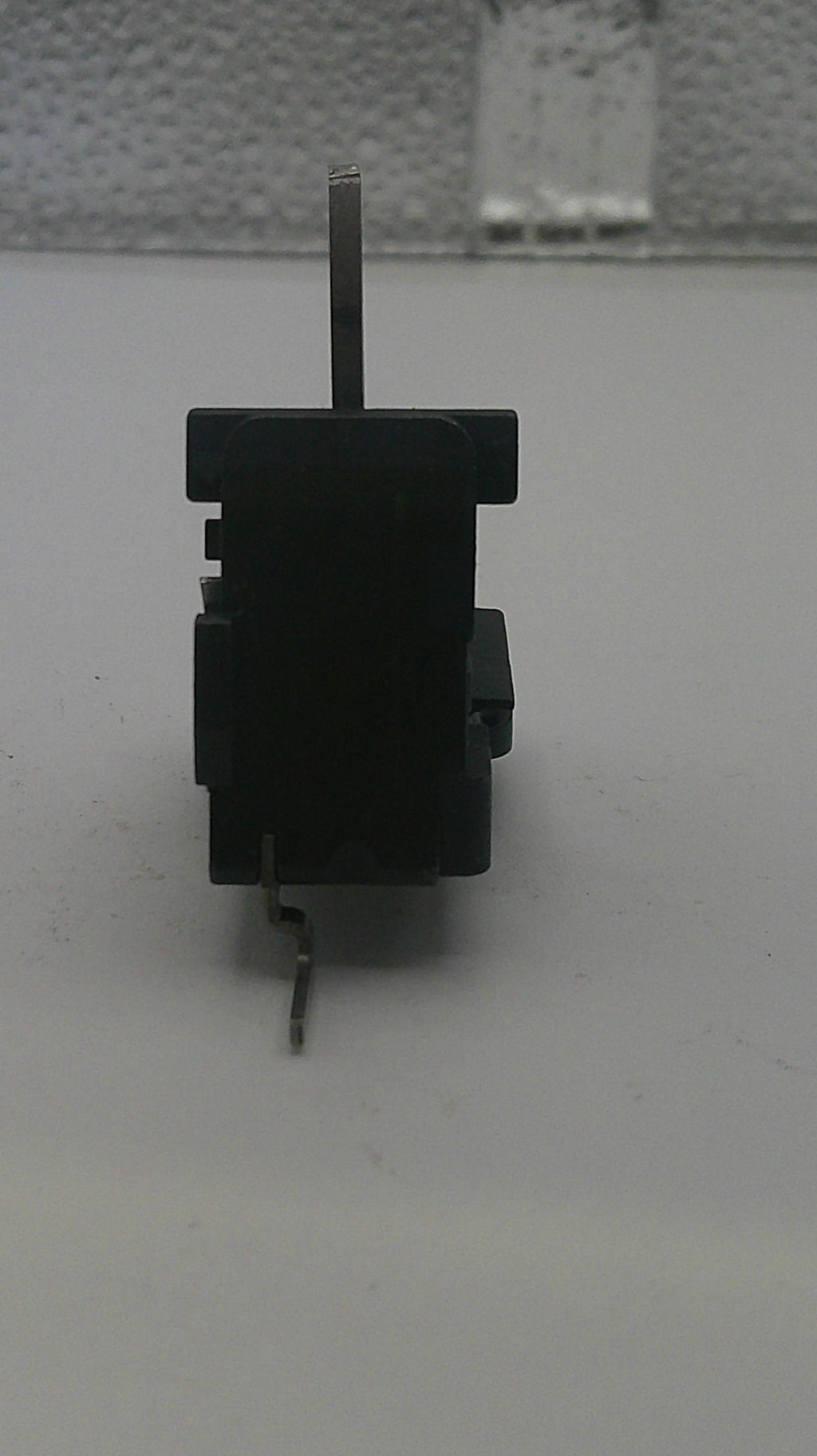 Small black mechanical component on a white background