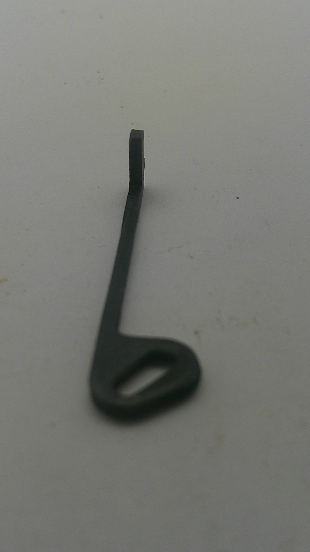 A small black metal hook or bracket with a looped end, photographed against a plain off-white background.
