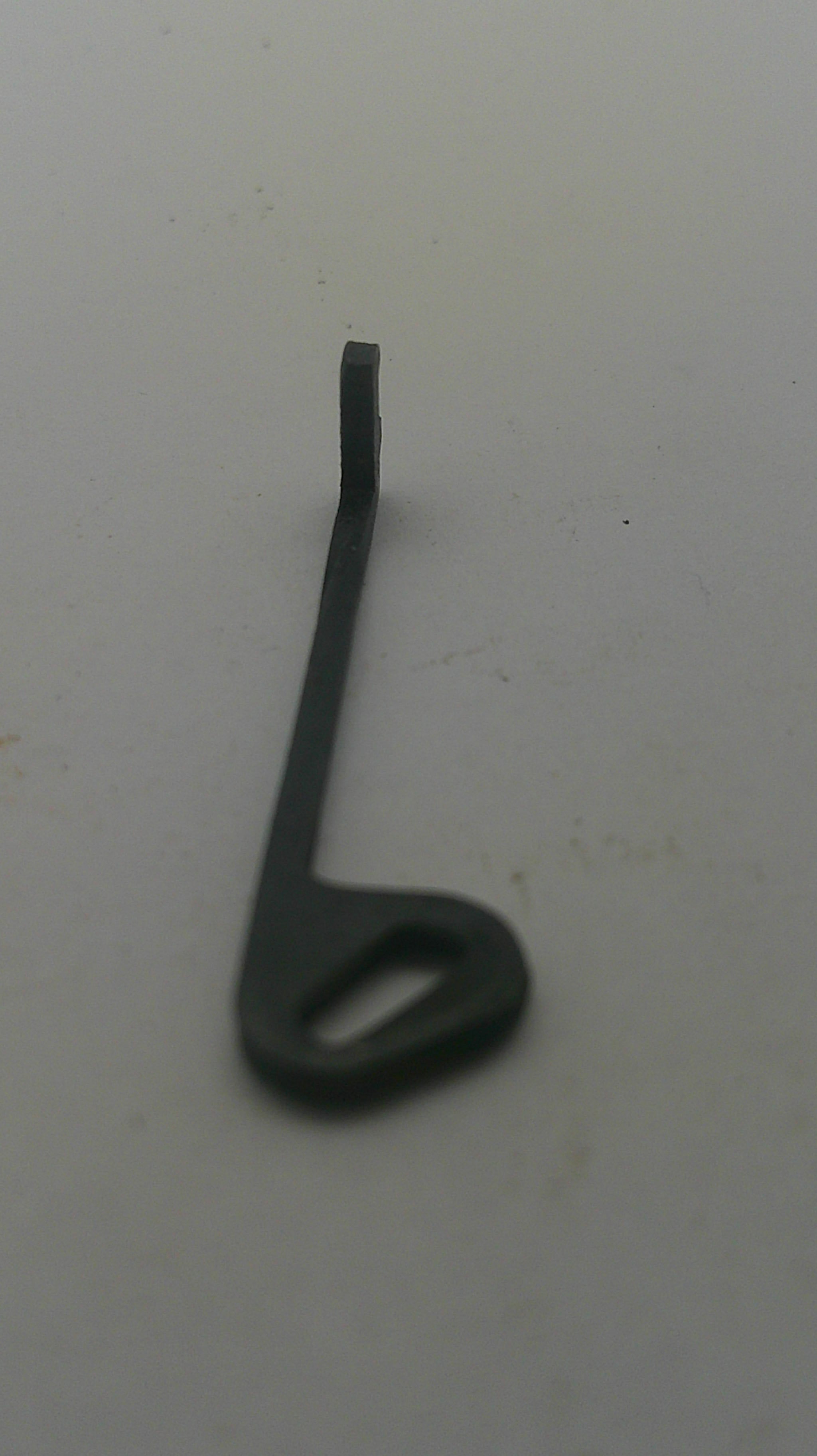 A small black metal hook or bracket with a looped end, photographed against a plain off-white background.
