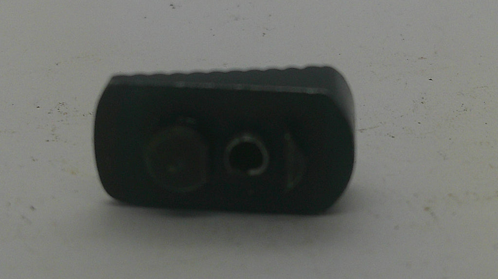 A small black plastic component with two circular openings, photographed on a plain light gray surface.