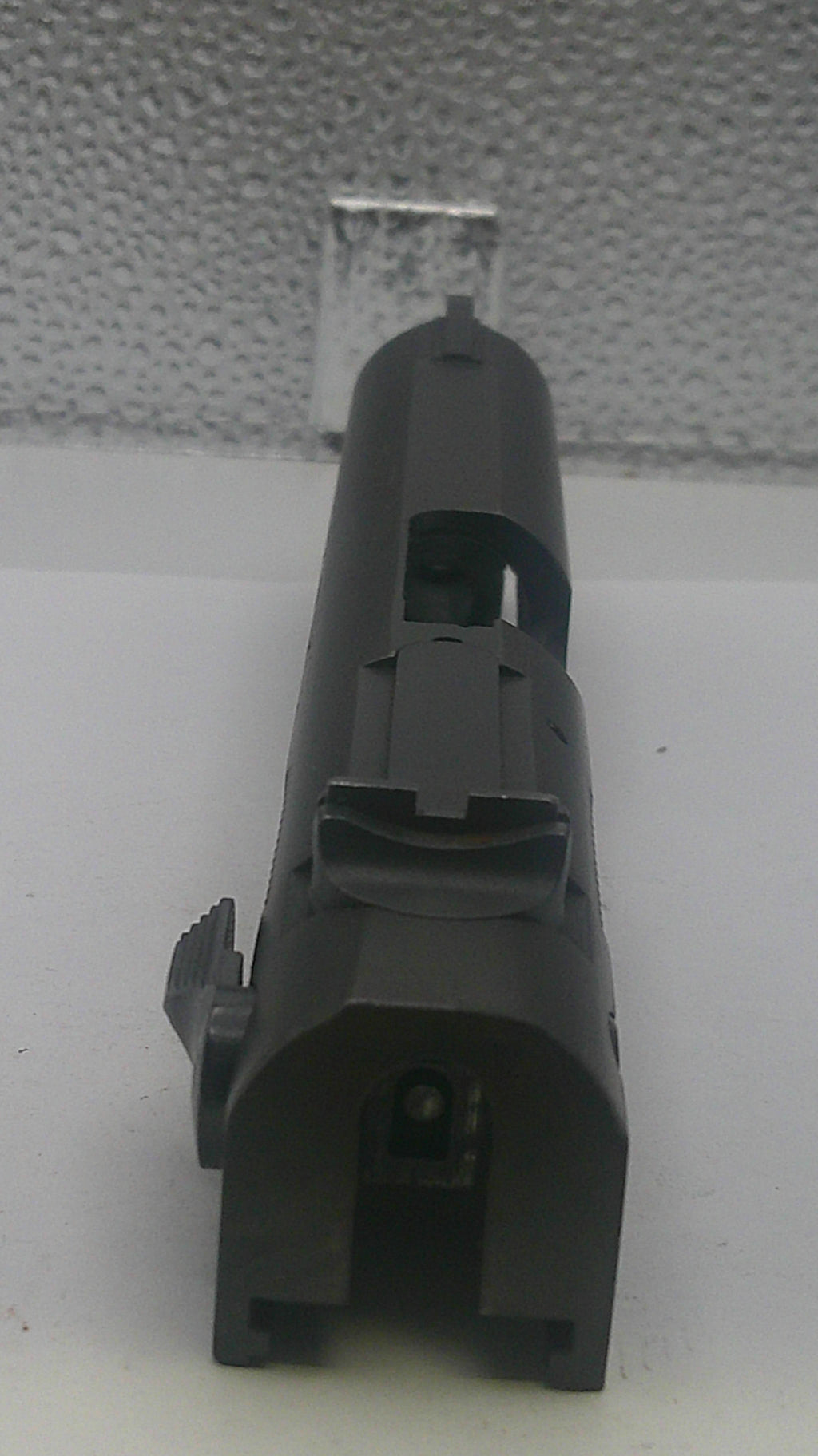 Black cylindrical object on a textured white surface