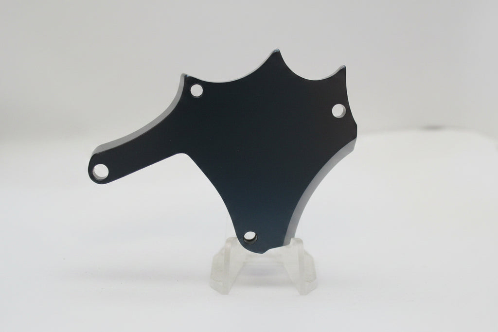 A dark, shield-shaped metal or plastic mounting bracket with two screw holes, displayed on a small white stand against a plain light background.