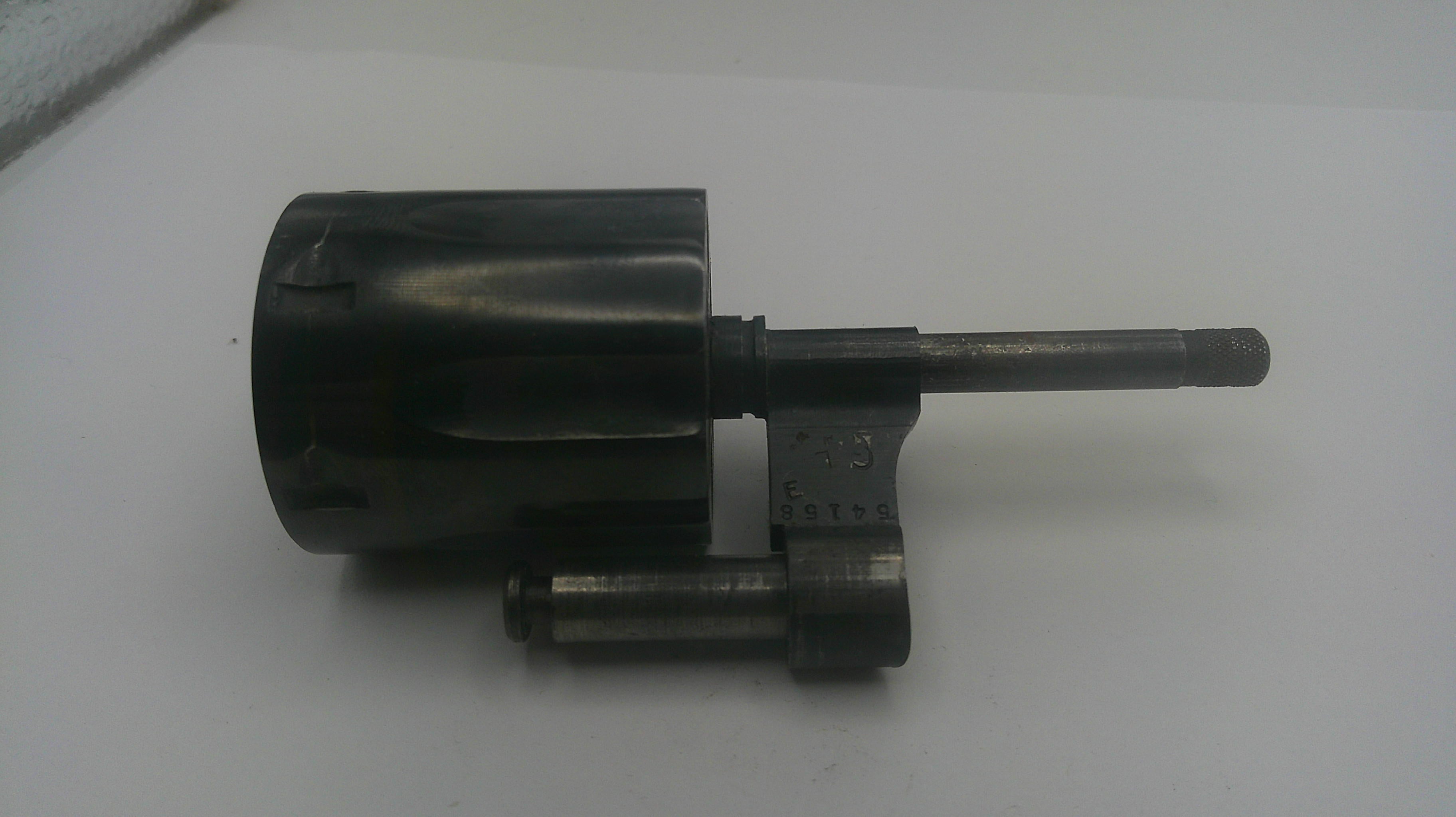 A used black metal mechanical part, possibly a pump or motor assembly with a long shaft, photographed on a plain white surface.