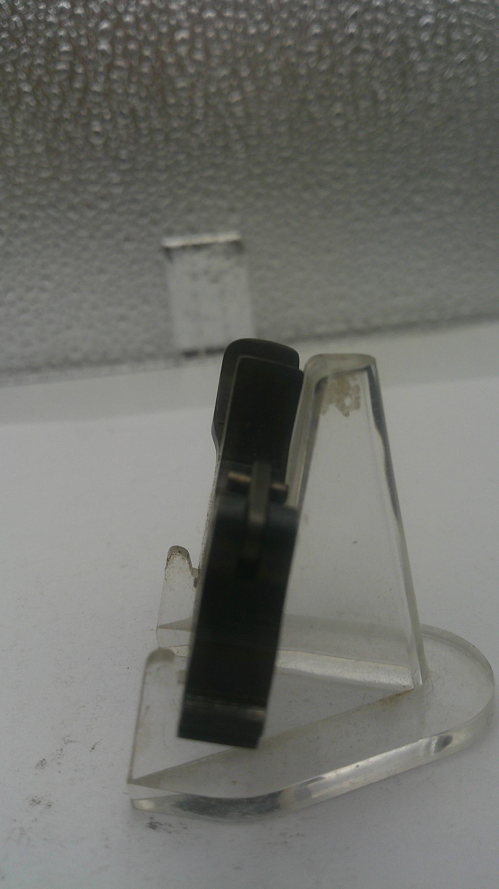 Clear plastic clip on a textured white surface