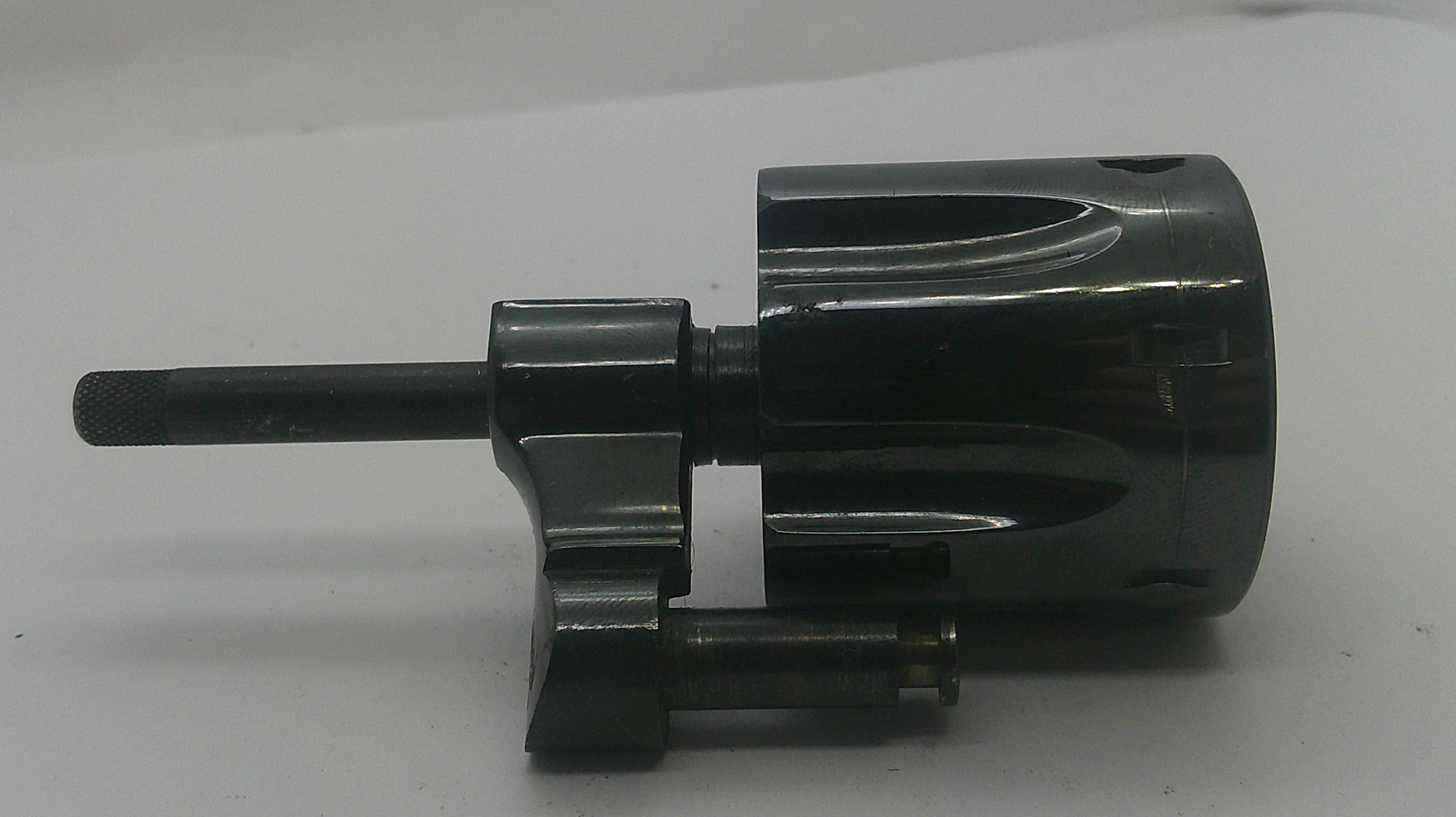 A black metal mechanical component with a cylindrical body, a protruding shaft, and a small attached rod, photographed on a plain light background.
