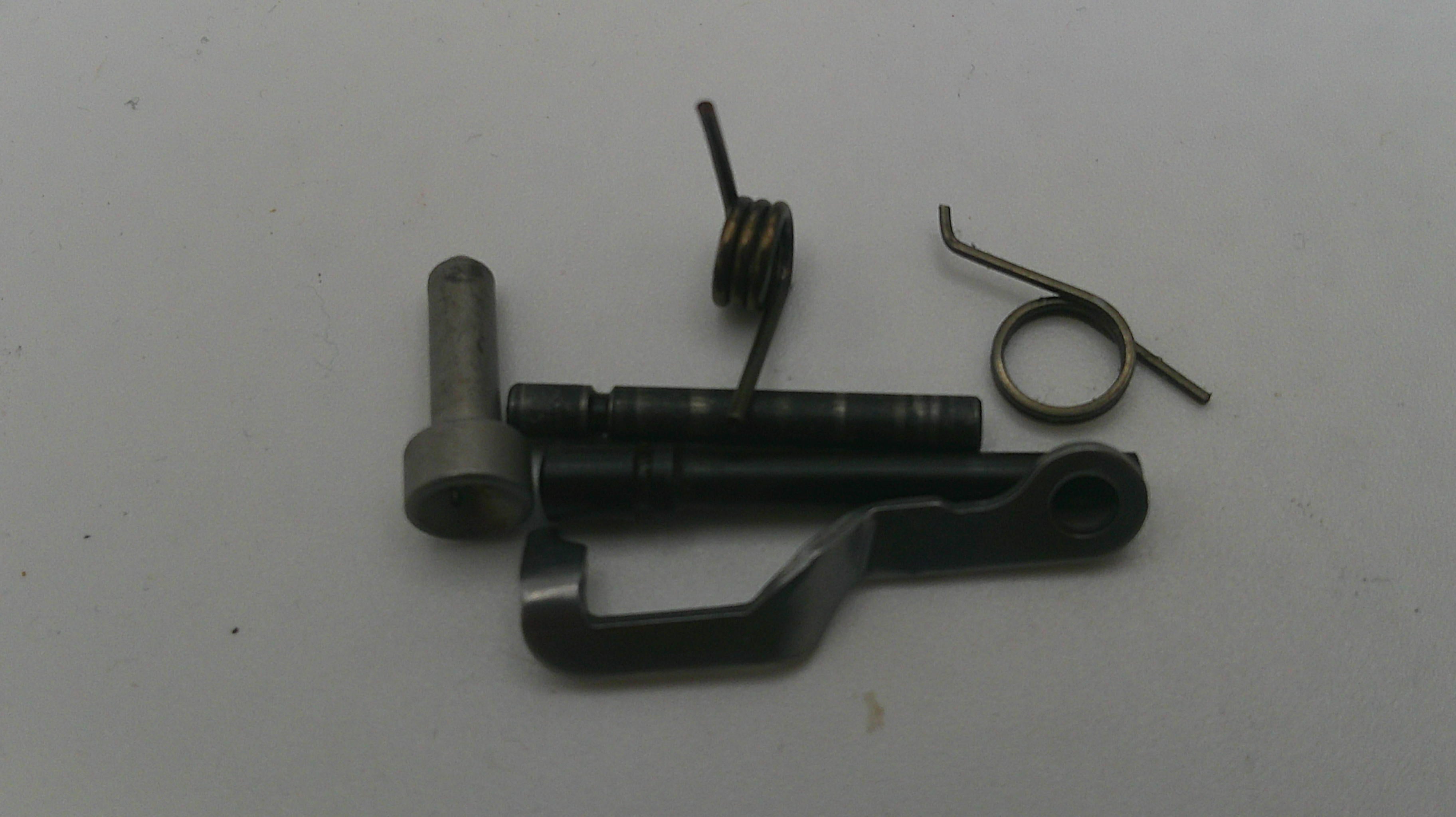 Mechanical parts including a metal rod, spring, and other components on a white background