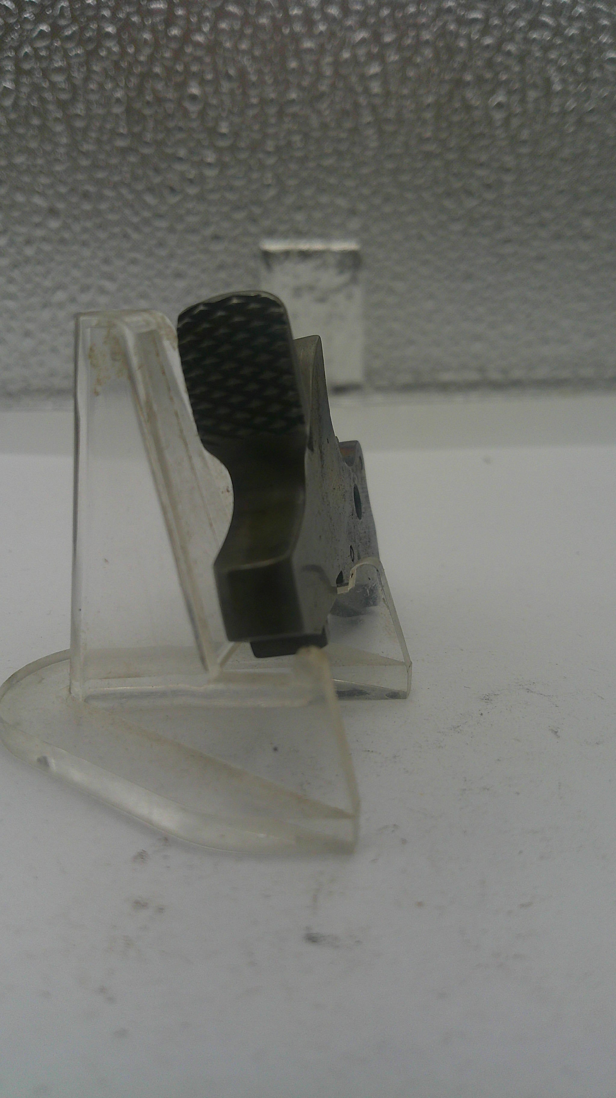Clear plastic clip with black component on a textured white background