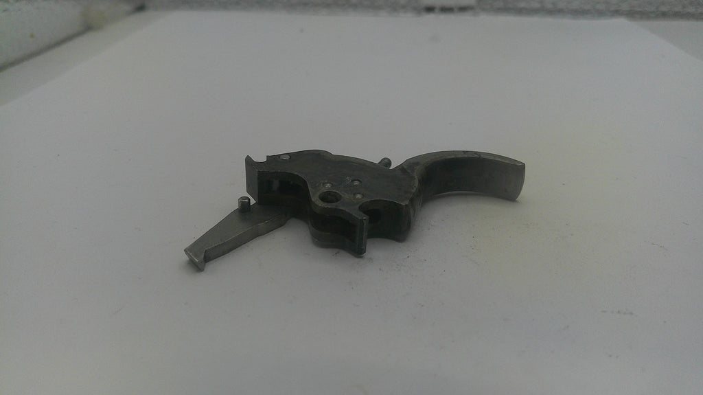 Metallic gun part on a white surface