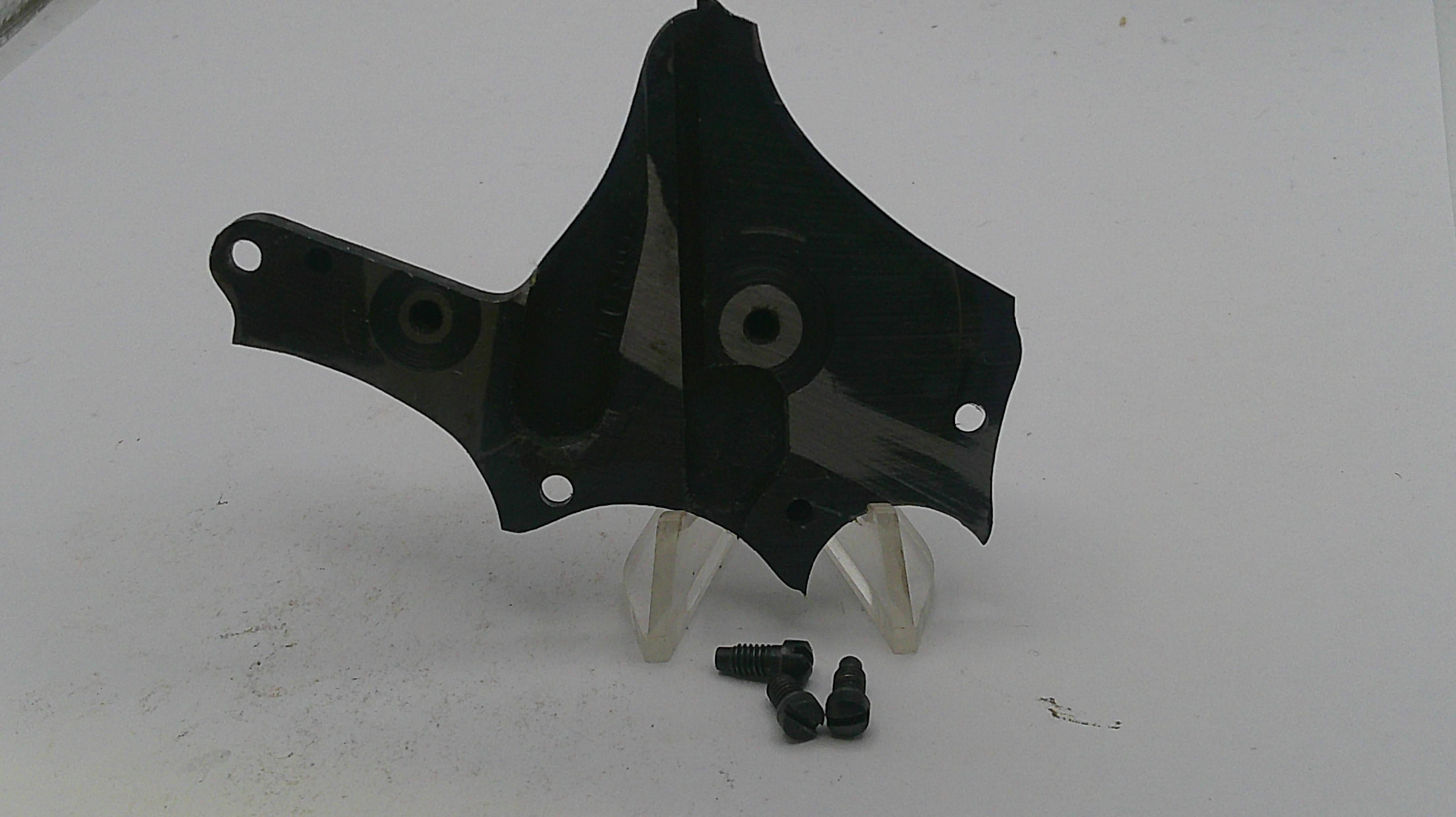 Black plastic car part with screws on a white background