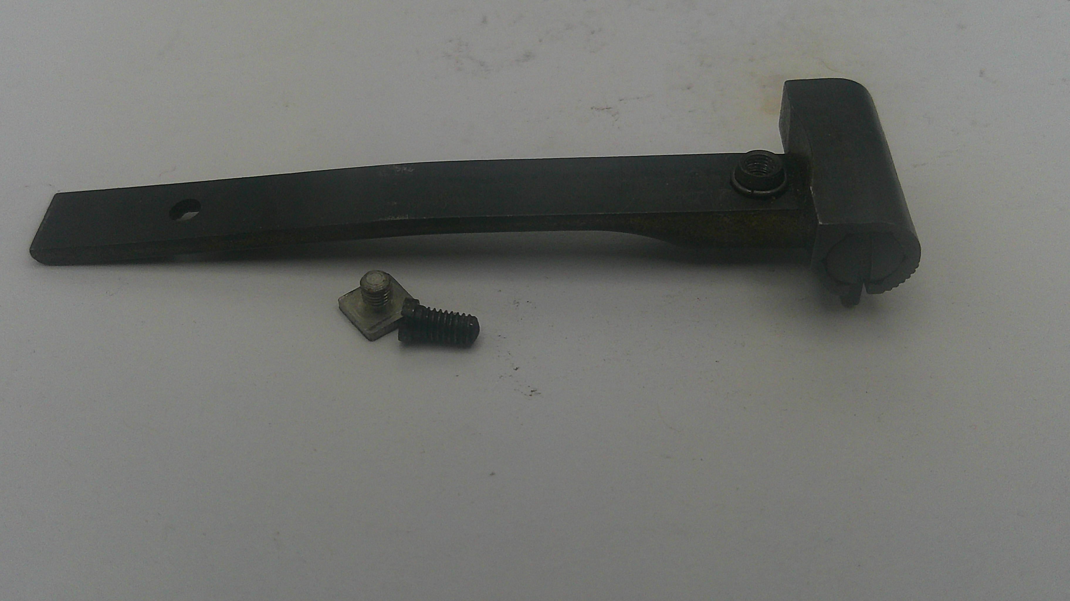 A black metal latch bracket with a small matching screw and washer, shown on a plain off-white surface.
