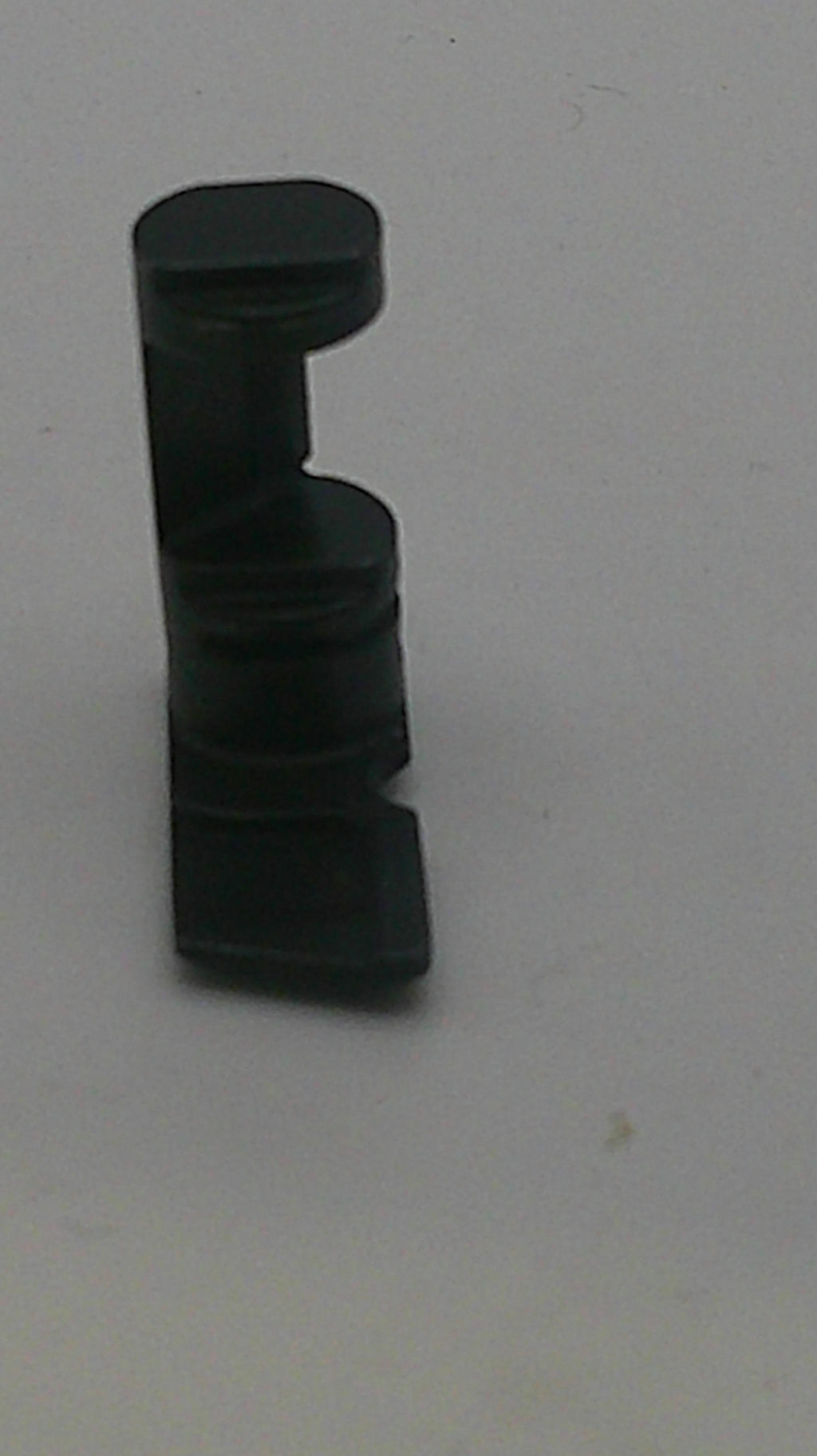 Black plastic component on a white background