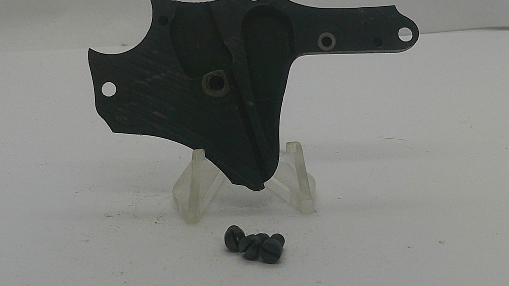 A black plastic motorcycle or bicycle handlebar clamp assembly with mounting holes, displayed on a clear plastic stand with four black screws below, on a white background.