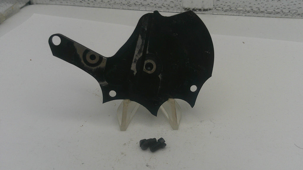 Black motorcycle fairing with screws on a white surface