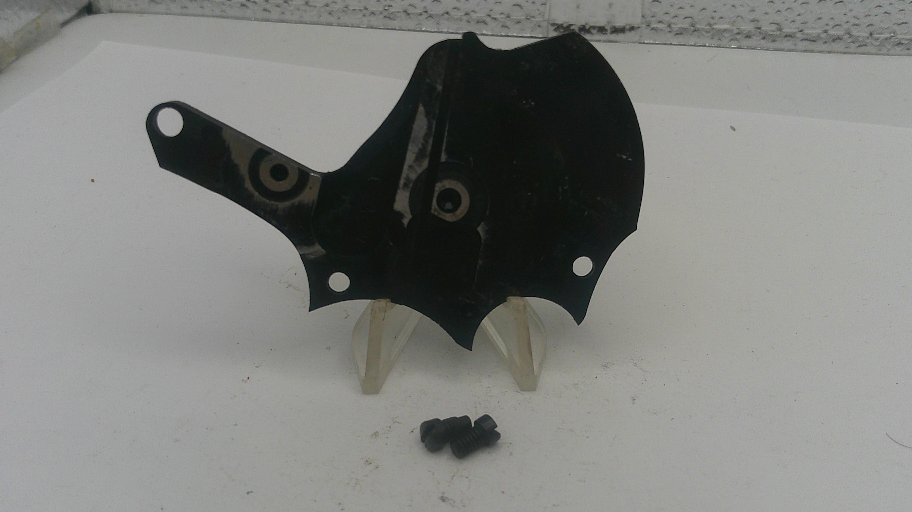 Black motorcycle fairing with screws on a white surface