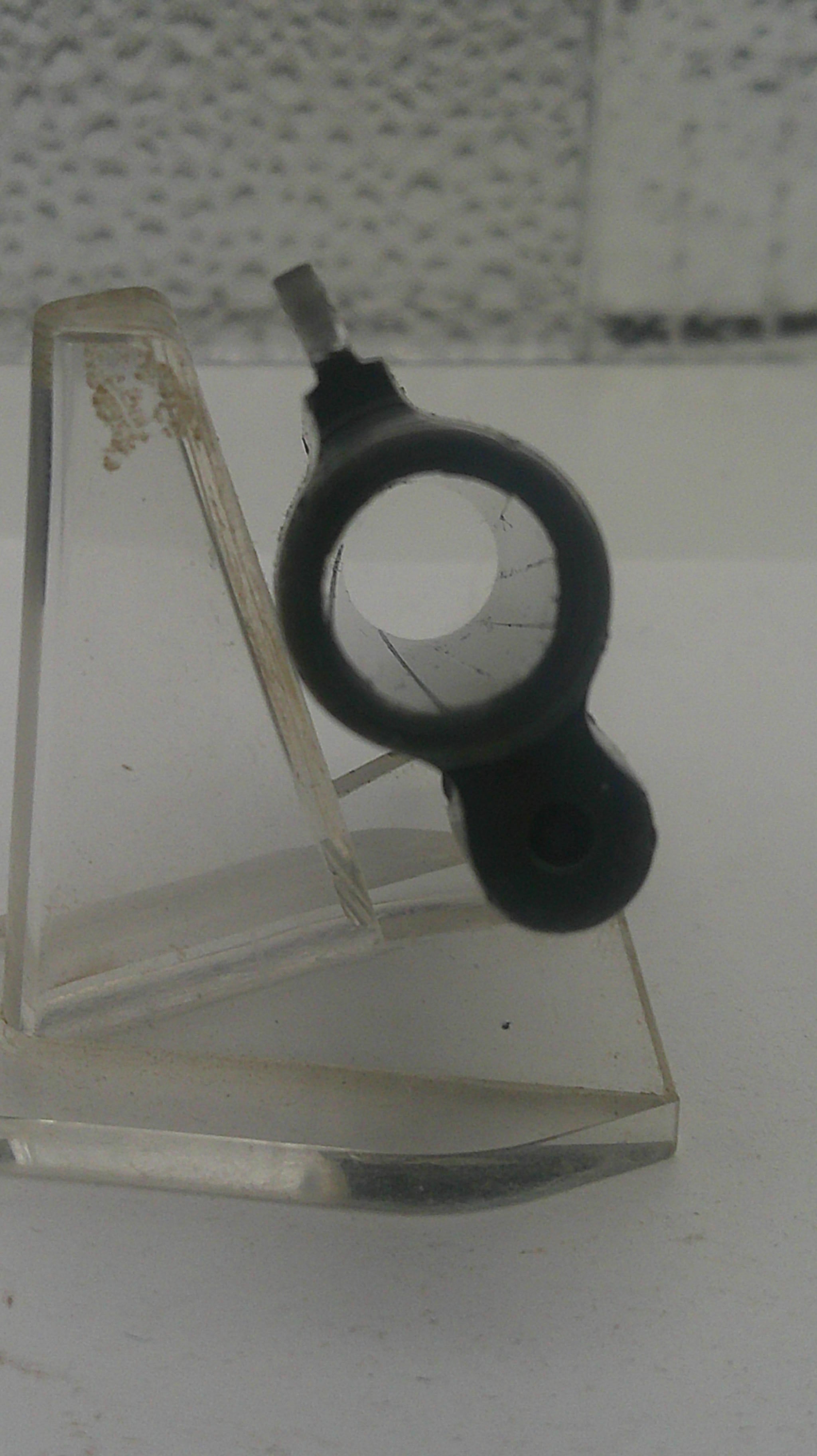 Black rubber gasket on a glass panel with a textured wall background