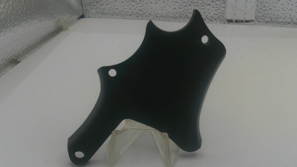 Black motorcycle fender on a white surface with a speckled gray background