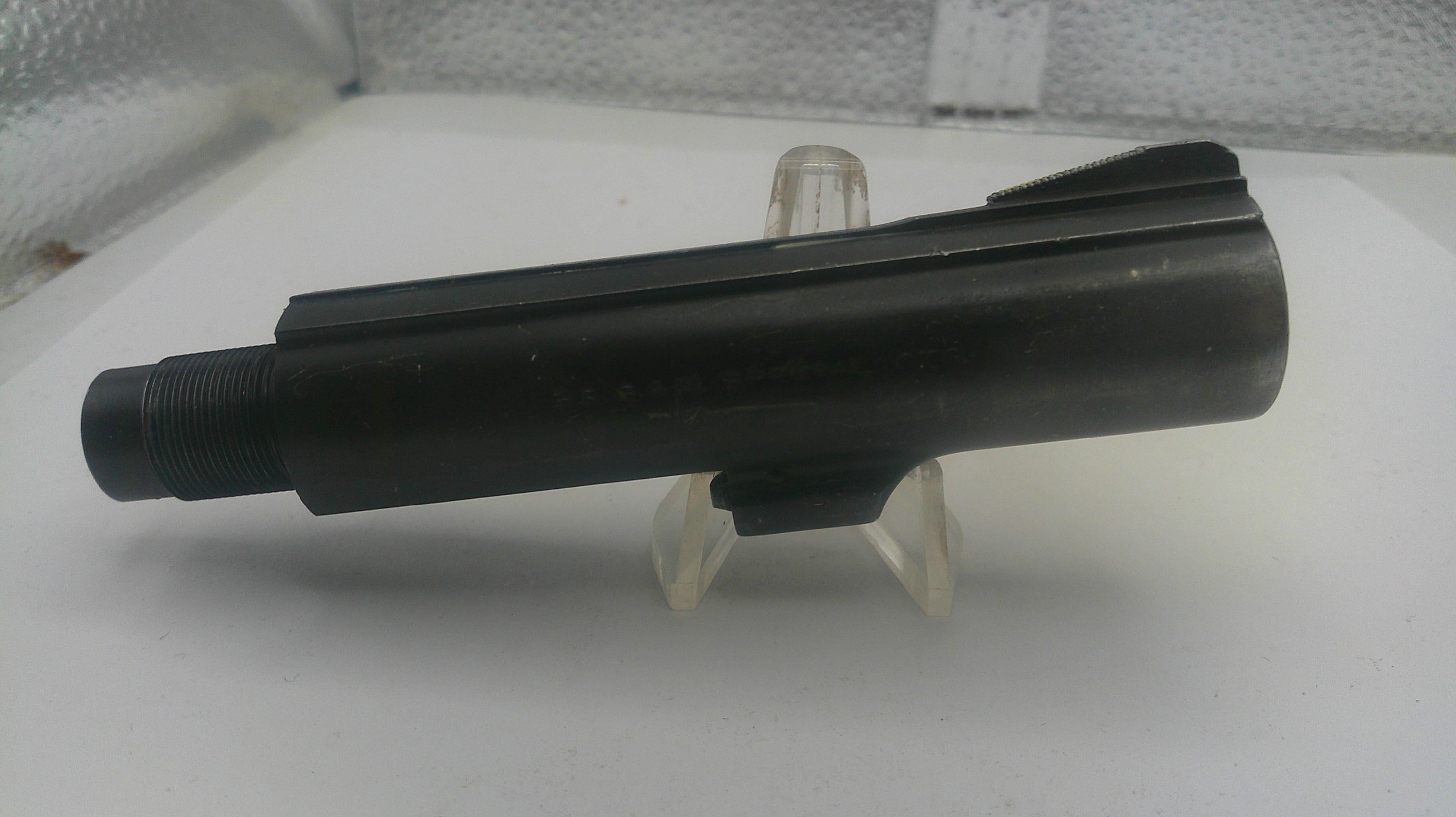 Black metal component on a white stand with a white background