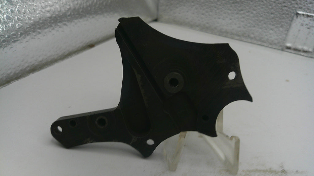 Black metal bracket on a white surface with a reflective background