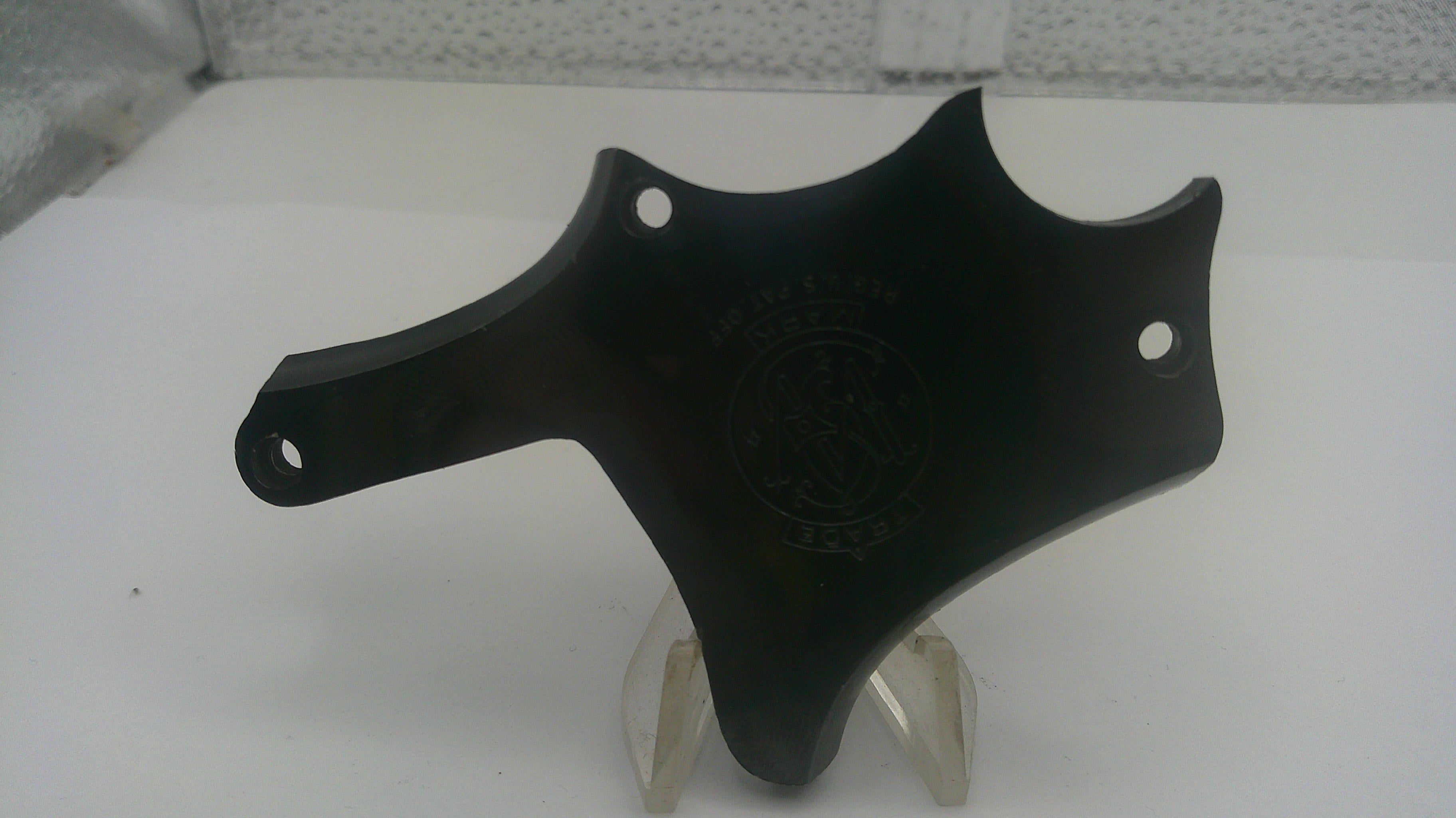 A black molded plastic or metal mounting plate with pre-drilled holes, displayed on a clear plastic stand against a white background.