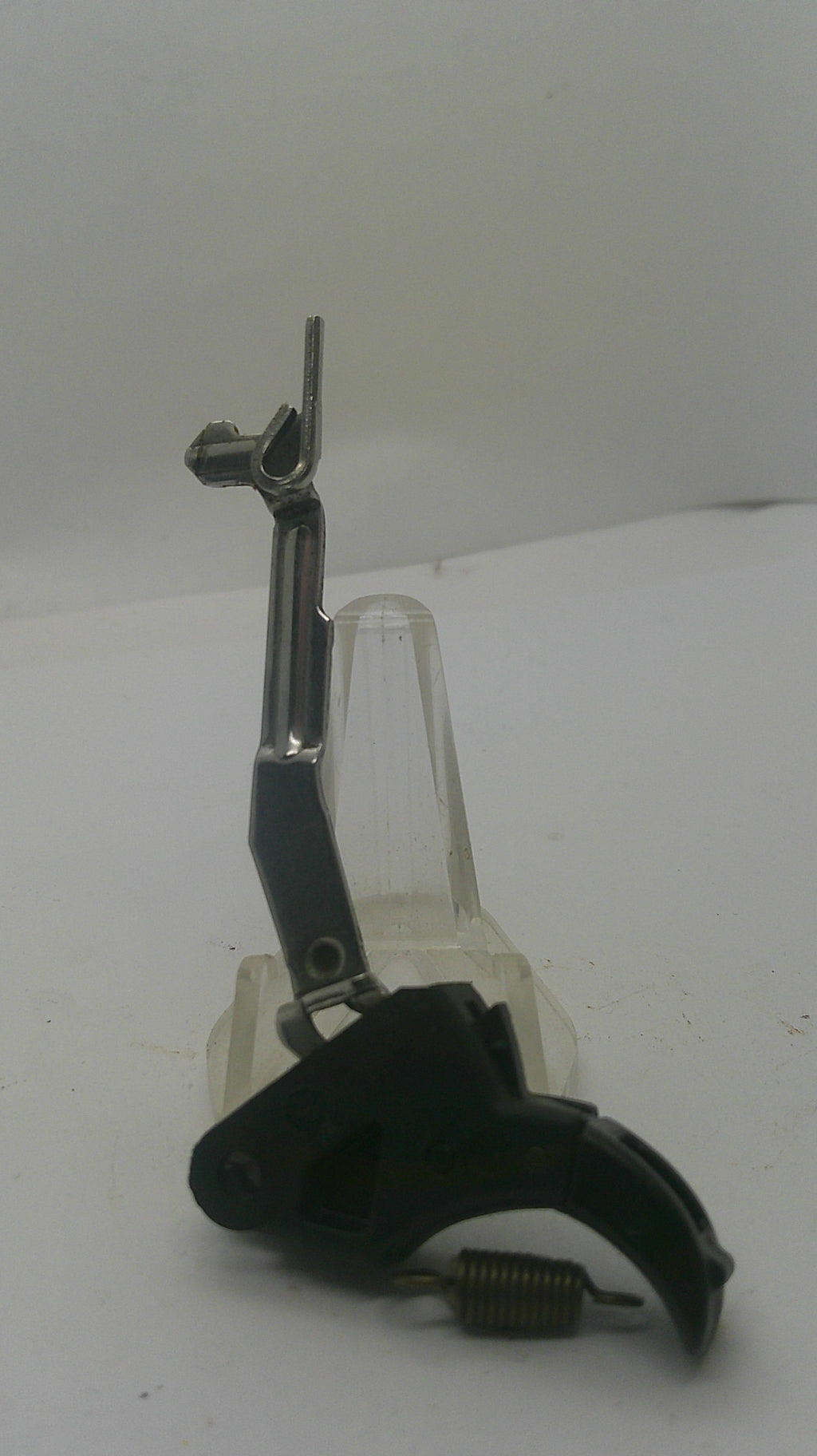 A replacement firearm trigger assembly with a black pistol grip, black safety switch, silver metal barrel shank, and clear plastic guard, shown against a plain white background.
