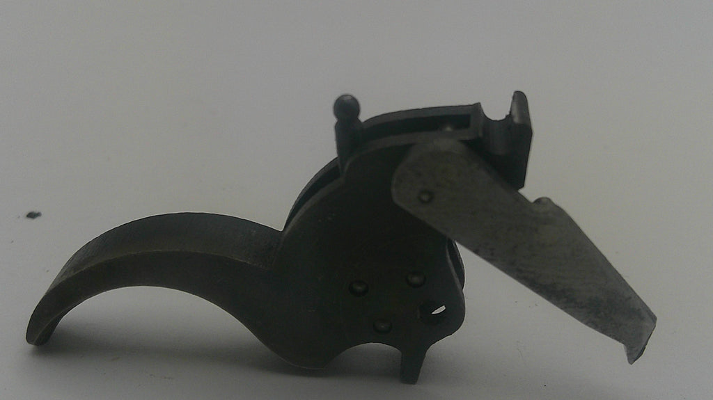 A dark metal firearm trigger assembly with a curved black handle and a silver-toned metal lever, photographed on a plain light gray background.
