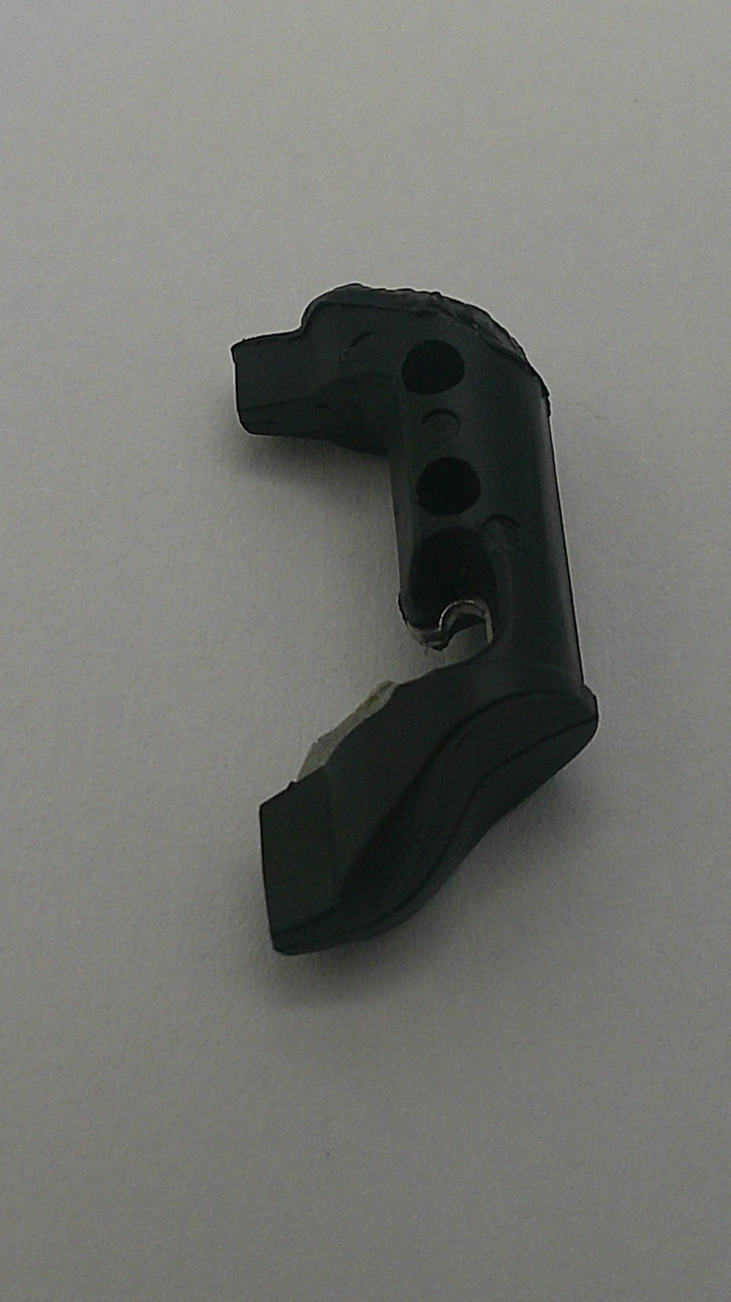 Black plastic component on a gray background