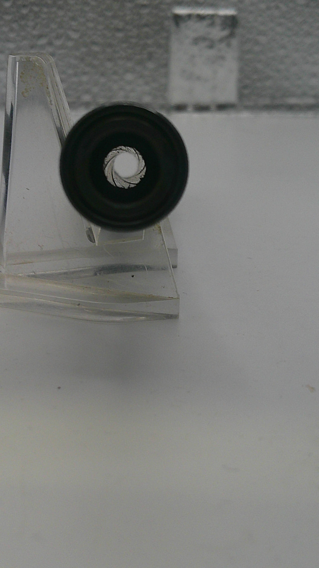 Close-up of a metallic object with a circular component on a white background