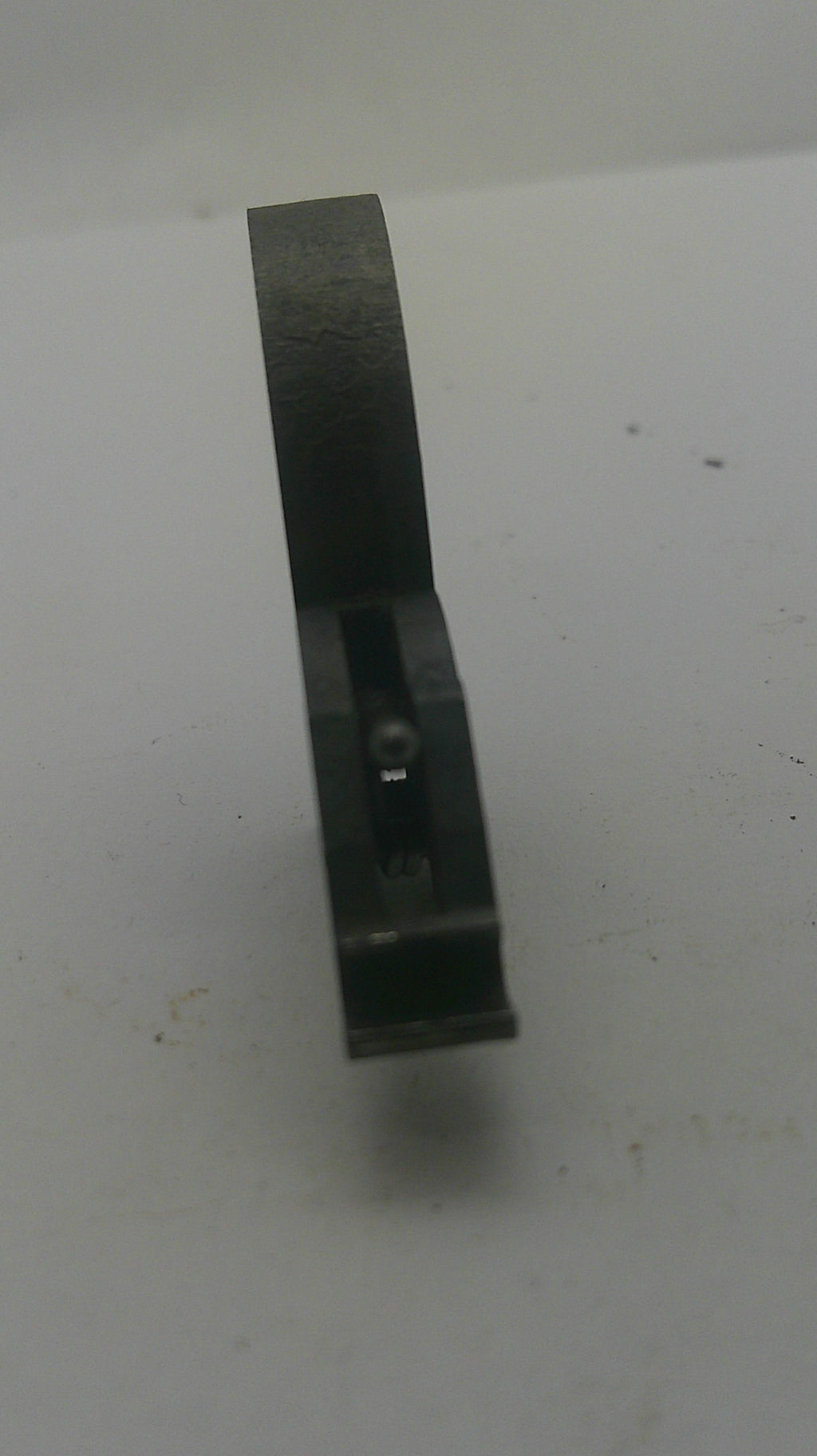 A dark metal flathead chisel with a black handle, photographed against a plain off-white background.